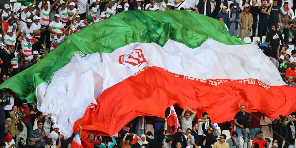 Iran women's football team standing in a line with arms around each other on the pitch in Queensland