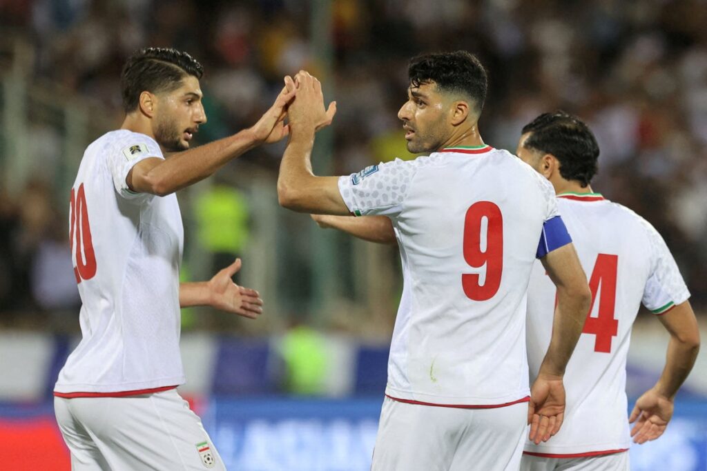 Iranian national football team players lining up on the pitch before a match