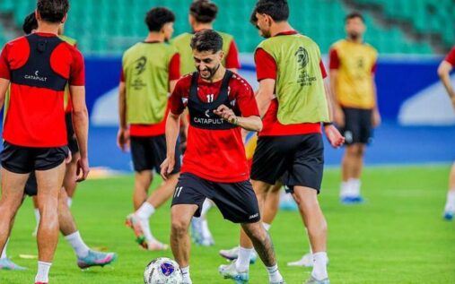 Iraq national football team players lining up on the pitch before an international match