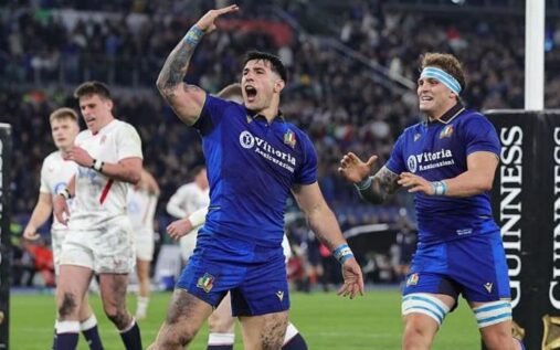 Italy rugby players celebrating on the pitch at the Stadio Olimpico after beating England