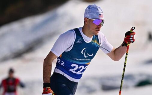 American cross-country skier Jake Adicoff celebrating his Paralympic gold medal victory at the Milan-Cortina Games