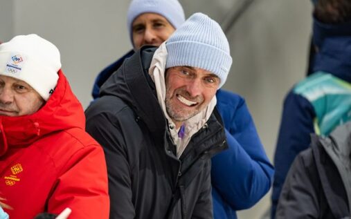 Jurgen Klopp smiling while watching a football match from the stands