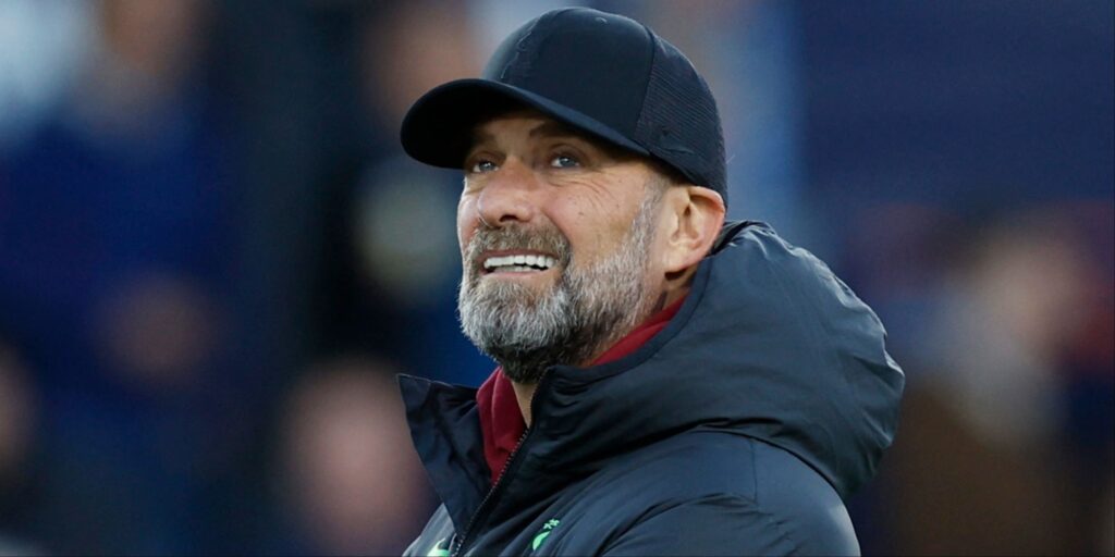 Jurgen Klopp smiling and wearing a baseball cap during a football match