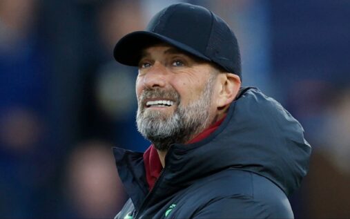 Jurgen Klopp smiling and wearing a baseball cap during a football match