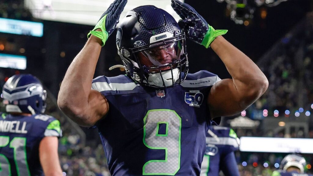 Kenneth Walker III carrying the football during a game
