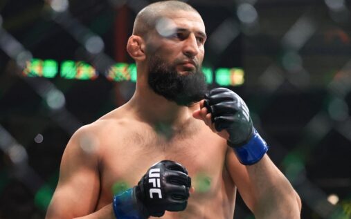 Khamzat Chimaev posing aggressively with the UFC middleweight championship belt