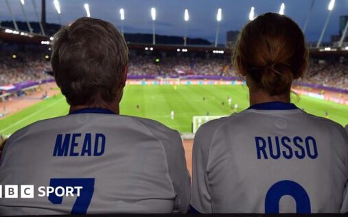Female football fans watching a match from the stadium stands