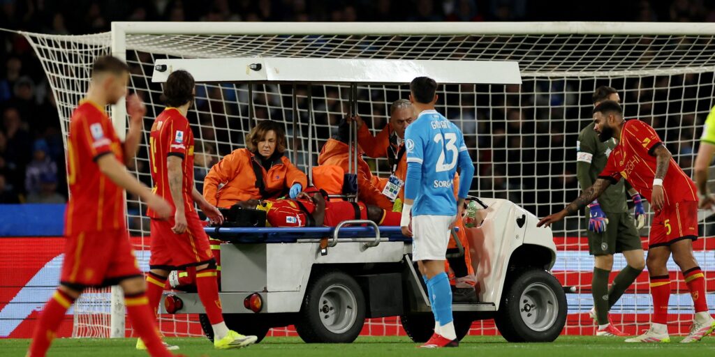 Lecce medical staff attending to Lameck Banda on the pitch