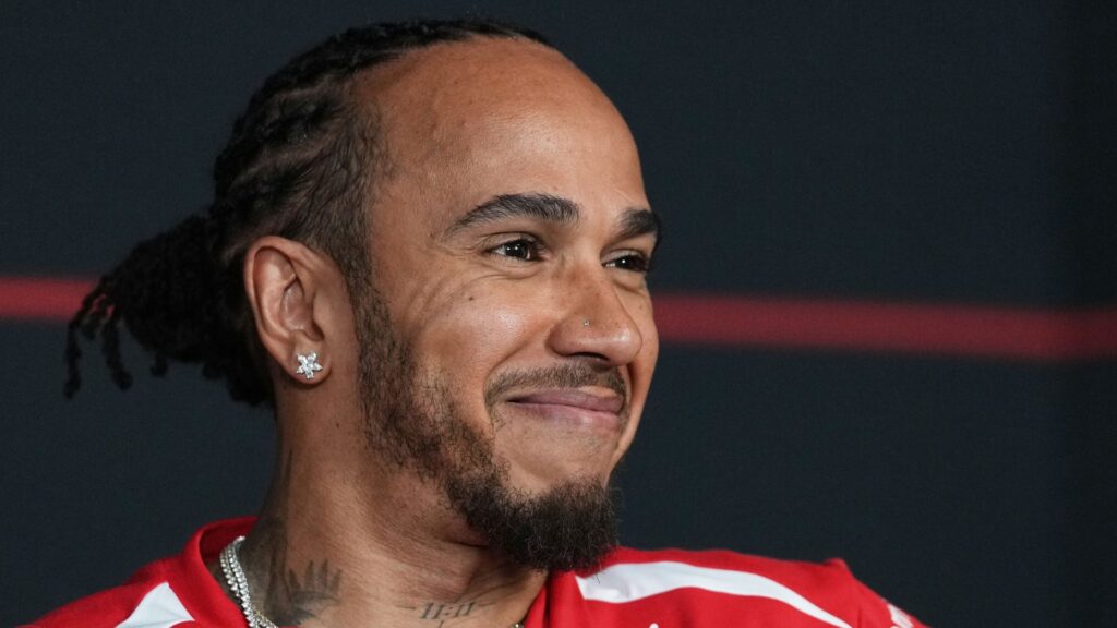 Lewis Hamilton wearing Ferrari team kit speaking at a press conference ahead of the Australian Grand Prix