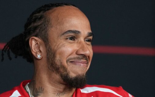 Lewis Hamilton wearing Ferrari team kit speaking at a press conference ahead of the Australian Grand Prix