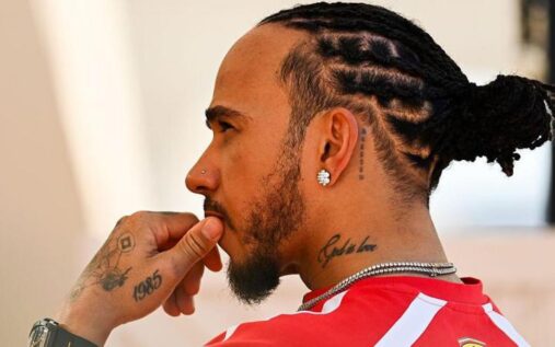 Lewis Hamilton speaking to the media in the paddock wearing Ferrari teamwear