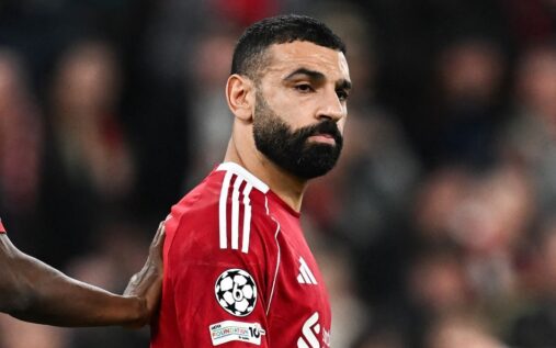 Mohamed Salah applauding Liverpool fans at Anfield wearing the red home kit