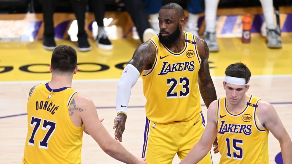 LeBron James and Luka Doncic standing together on the basketball court in Los Angeles Lakers uniforms