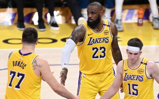 LeBron James and Luka Doncic standing together on the basketball court in Los Angeles Lakers uniforms