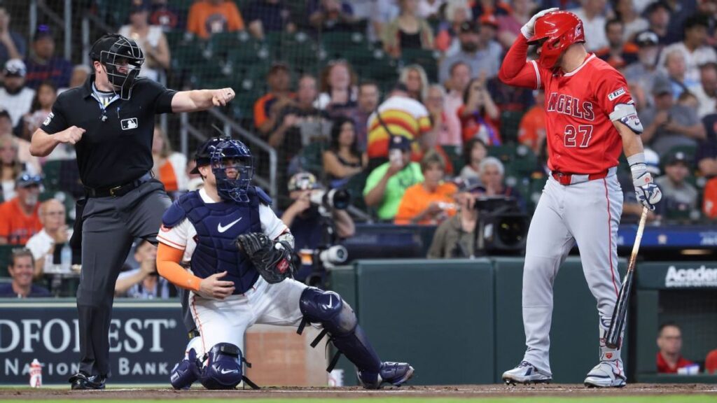 Eugenio Suarez taps his head to signal an automated ball-strike challenge during a Cincinnati Reds match