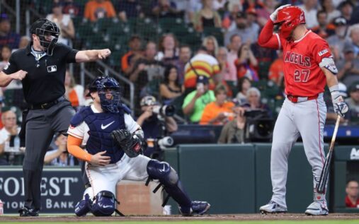 Eugenio Suarez taps his head to signal an automated ball-strike challenge during a Cincinnati Reds match
