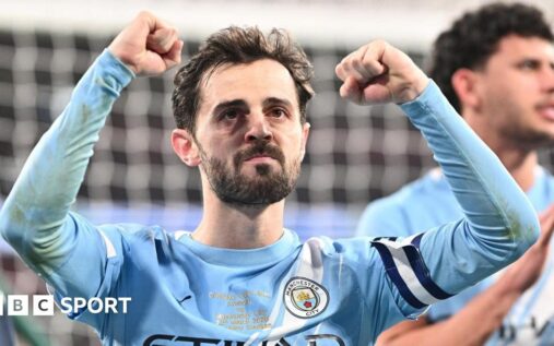 Bernardo Silva holding the Carabao Cup trophy in his Manchester City kit