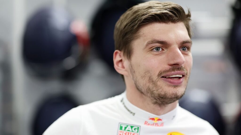 Max Verstappen looking frustrated while wearing his Red Bull Racing team uniform in the Formula 1 paddock