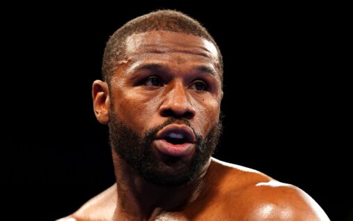 Floyd Mayweather standing in a boxing ring appearing confident