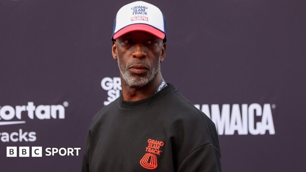 Michael Johnson looking serious while standing inside an athletics stadium