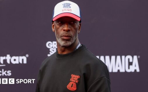 Michael Johnson looking serious while standing inside an athletics stadium
