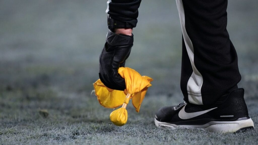 An NFL referee signalling a call on the field during an American football game