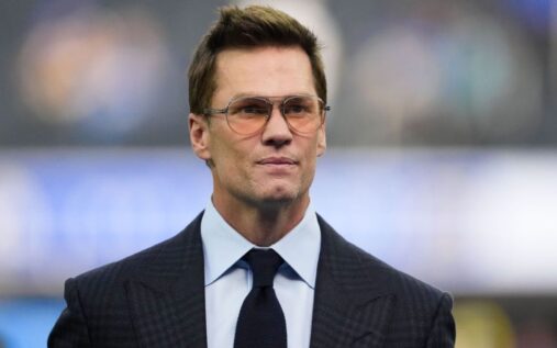 Tom Brady smiling in his role as minority owner of the Las Vegas Raiders