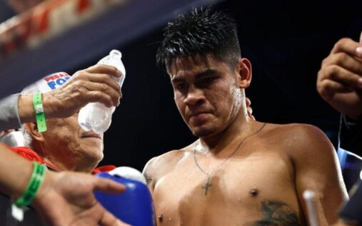 Emanuel Navarrete celebrating in the ring with both the IBF and WBO super-featherweight belts