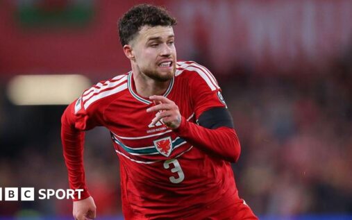 Neco Williams in action for Wales wearing the red international kit