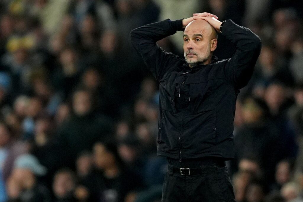 Pep Guardiola looking pensive on the touchline during a Manchester City match