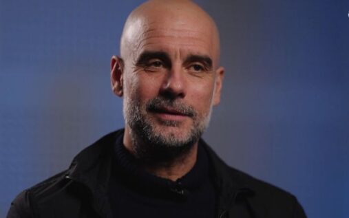 Pep Guardiola standing on the touchline during a Manchester City match
