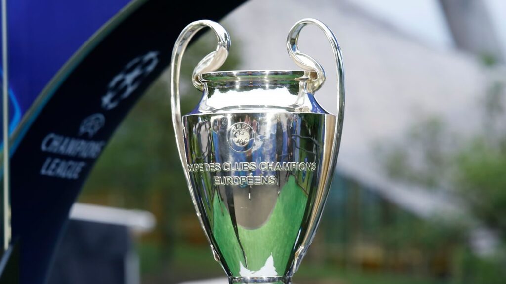 Premier League trophy surrounded by Champions League and Europa League footballs