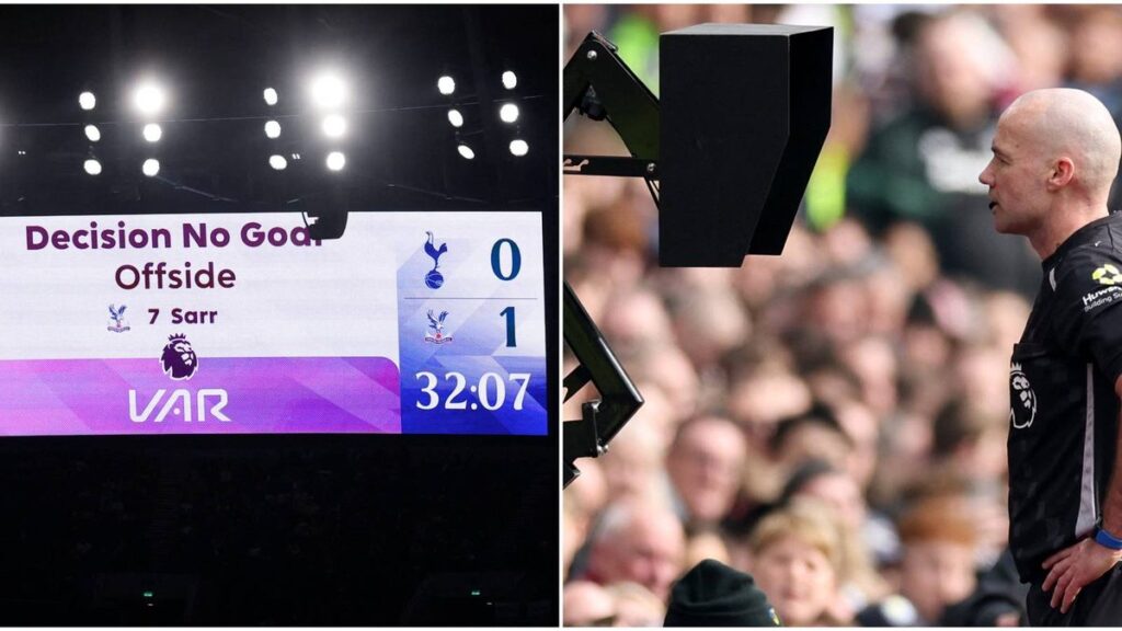 A football referee checking the pitch-side VAR monitor during a Premier League match.