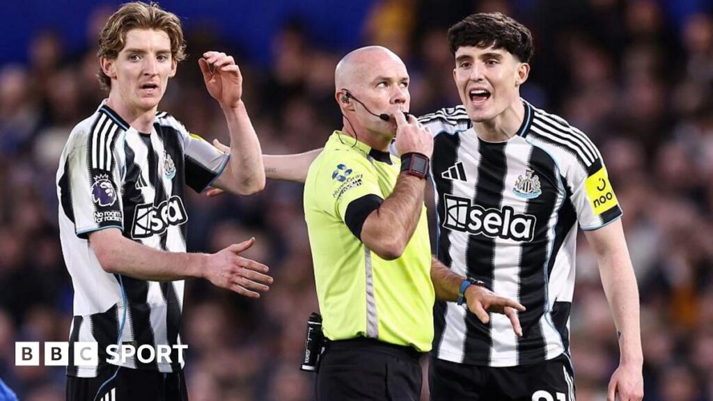 A Premier League referee consulting the VAR monitor on the touchline