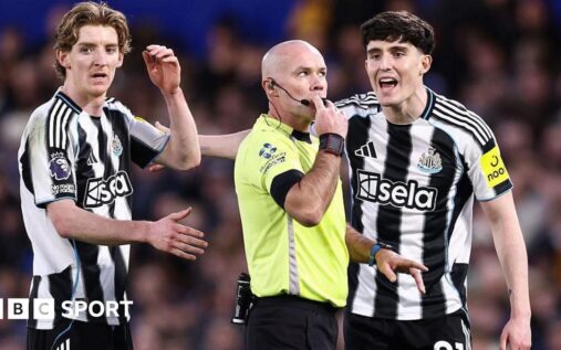 A Premier League referee consulting the VAR monitor on the touchline