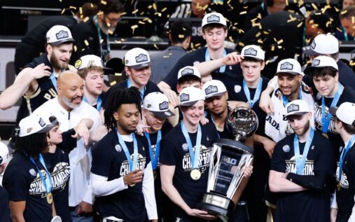 Purdue basketball players celebrating with the Big Ten tournament championship trophy after defeating Michigan