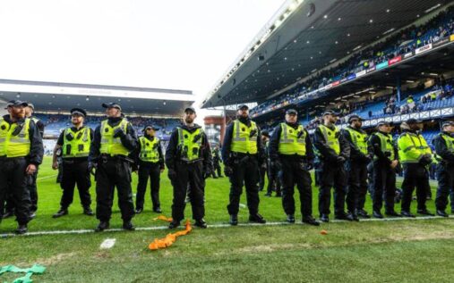 Police officers managing crowds outside Ibrox Stadium following an Old Firm football match