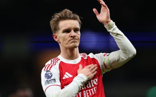 Arsenal captain Martin Odegaard applauding fans while wearing the red and white home kit