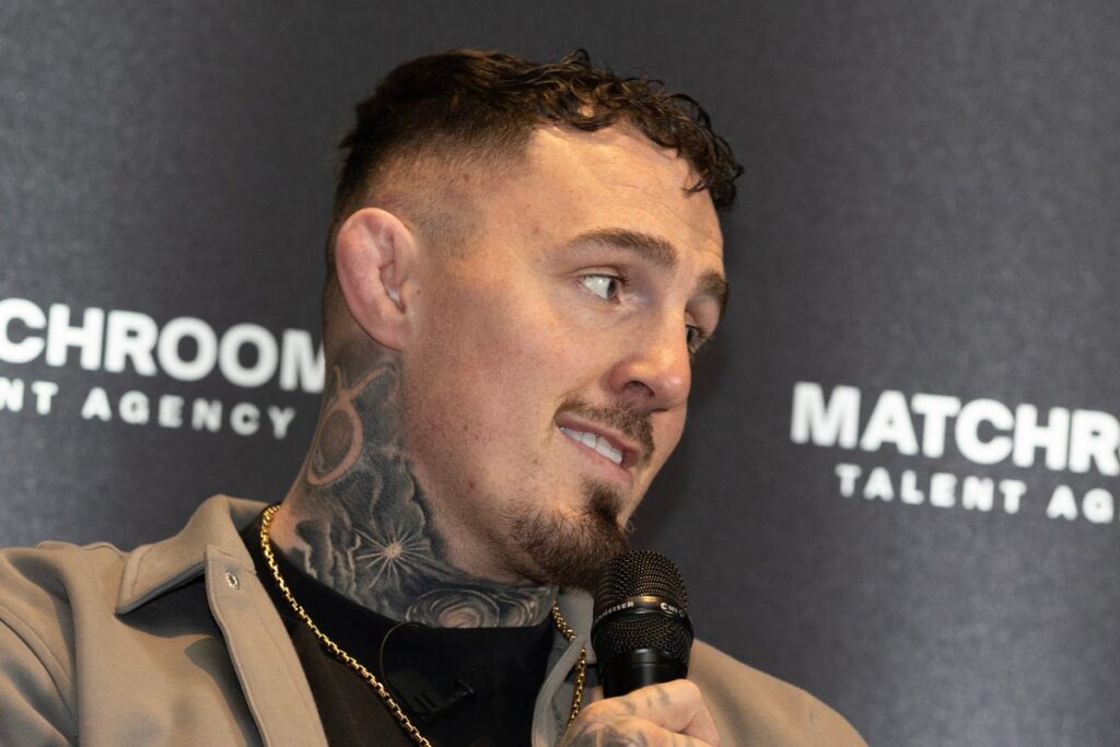 Tom Aspinall standing in the UFC octagon with his heavyweight championship belt