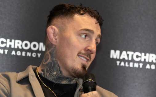 Tom Aspinall standing in the UFC octagon with his heavyweight championship belt