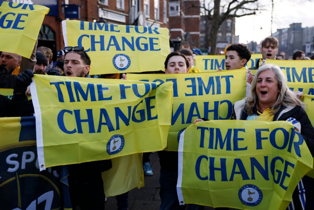 Tottenham Hotspur fans holding scarves and flags in the stands at the stadium