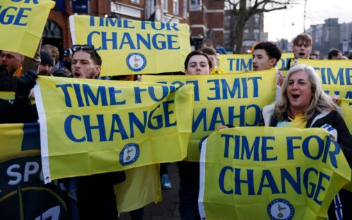 Tottenham Hotspur fans holding scarves and flags in the stands at the stadium