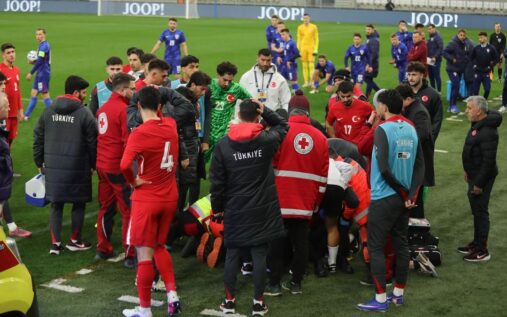 Medical staff treating a person on a stretcher inside a football stadium