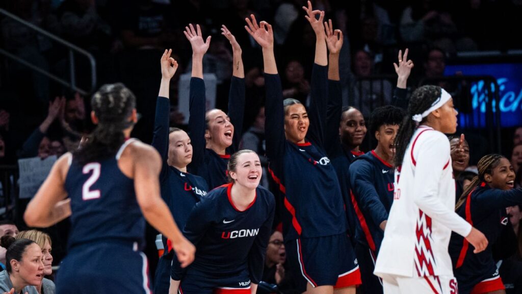 UConn women's basketball players celebrating on the court at Madison Square Garden