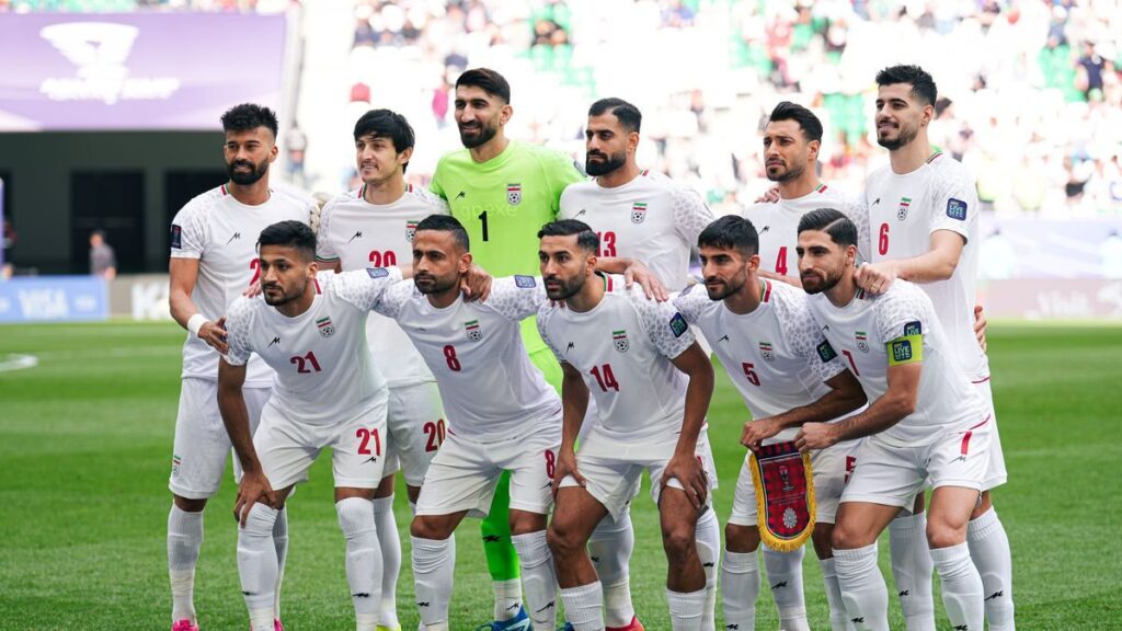 The Iran national football team lining up on the pitch before a match
