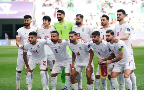 The Iran national football team lining up on the pitch before a match