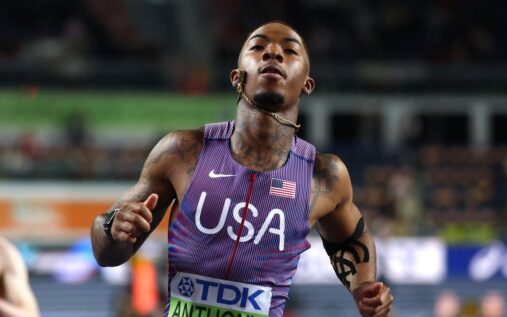 USA sprinter Jordan Anthony running on the track with a heavily taped left arm at the World Athletics Indoor Championships.