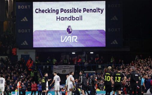 Referee looking at a VAR monitor on the side of a football pitch during a European match