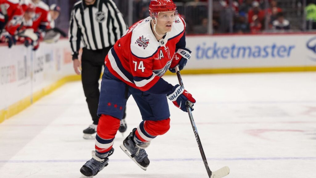 John Carlson skating with the puck in a Washington Capitals jersey