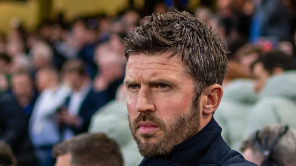 Michael Carrick standing on the touchline managing Manchester United during a Premier League match